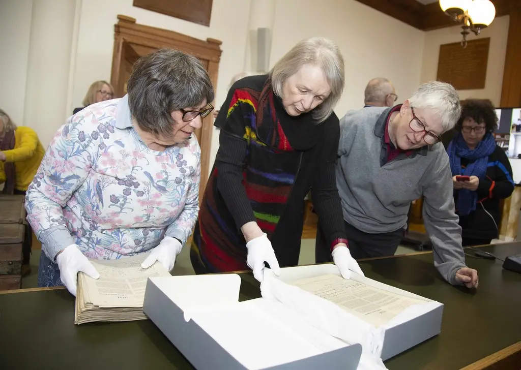 Foto: Heddwch Nain members studying §1923 Peace Petition archive boxes